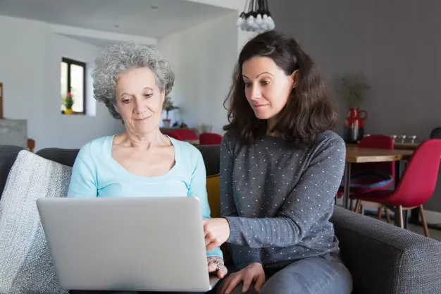 mulher jovem explicando vovo como uso laptop sobre o Desperta Débora