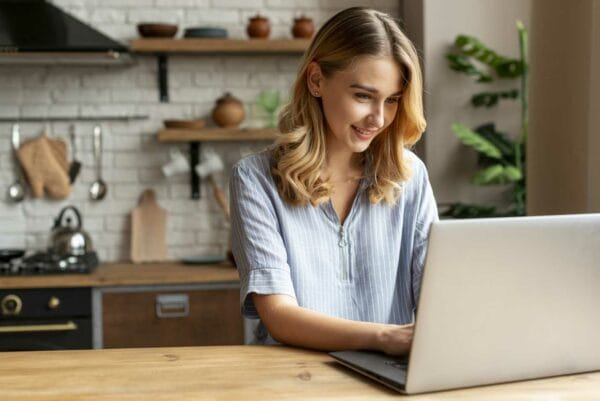Menor Mulher jovem sorridente usando o computador Desperta Debora