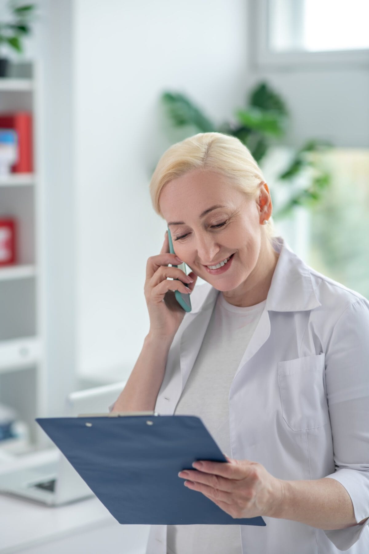 Mulher idosa no telefone prevalece o branco com prancheta Desperta Debora