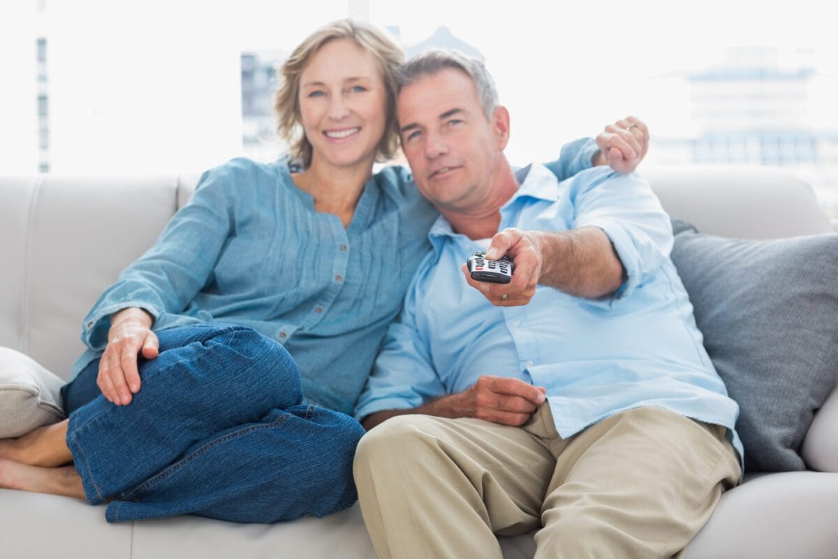 Casal feliz assistindo a Tv juntos no sofá, Desperta Débora