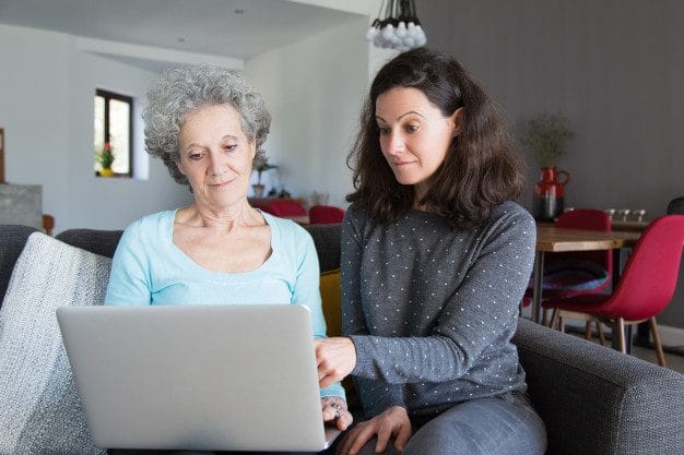 mulher jovem explicando vovo como uso laptop sobre o Desperta Débora