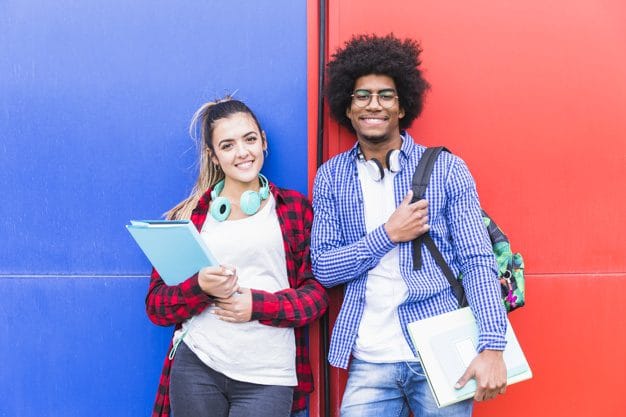 retrato de jovem sorrindo par adolescente segurando livros ficar contra vermelho azul parede 23 2148093117